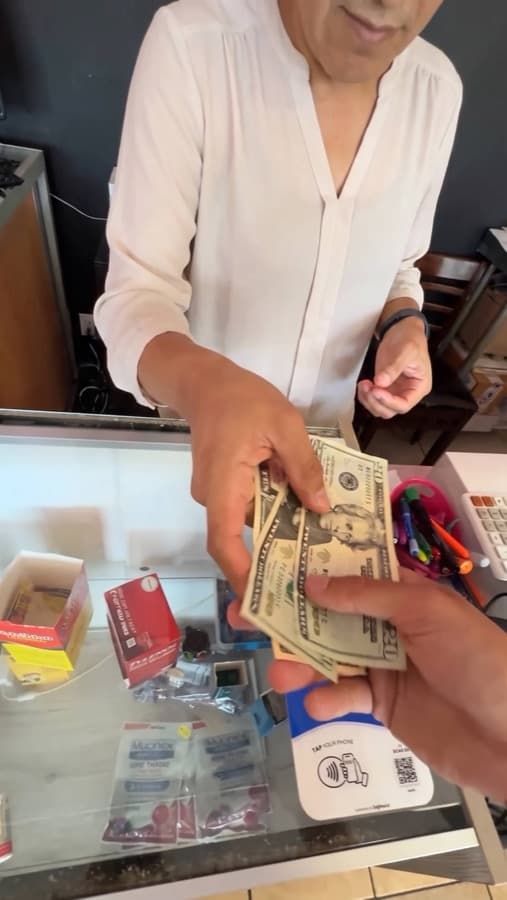 A Google review card on a shop counter, tapped with a phone (4)