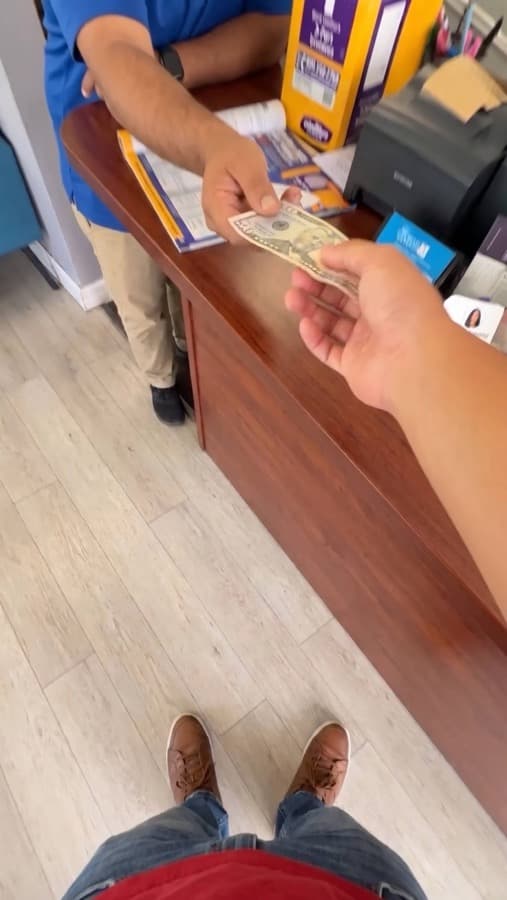A Google review card on a shop counter, tapped with a phone (6)